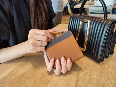 第3世代オールインワンL型ファスナー財布「Paradigm」の財布を持つ女性