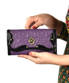 アナスイのアンティーク調のがま口かぶせ長財布（パープル）を持つ女性