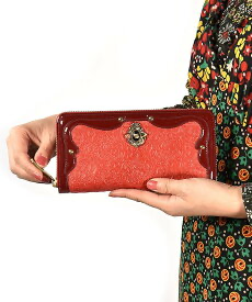 アナスイのアンティーク調のがま口かぶせ長財布（レッド）を持つ女性