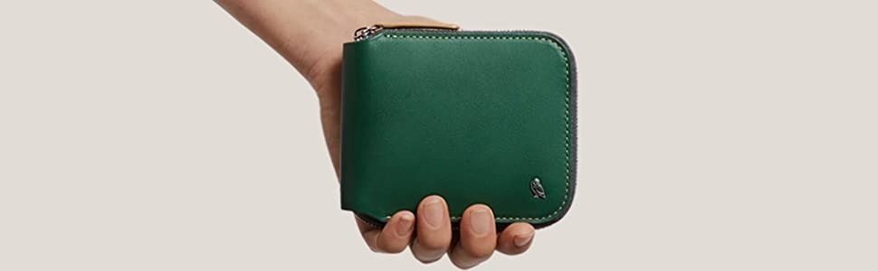 ベルロイの緑のラウンドジップ二つ折り財布を握る手
