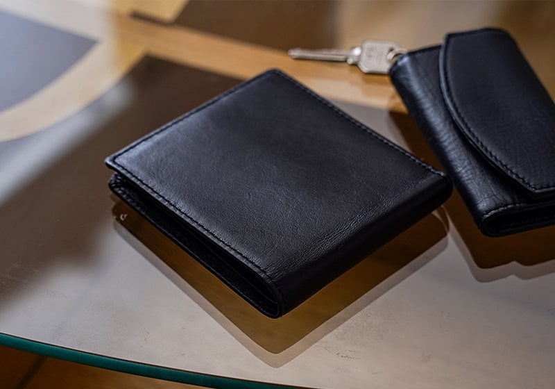 テーブルに置かれた二つ折り財布とキーケース（ネイビー）