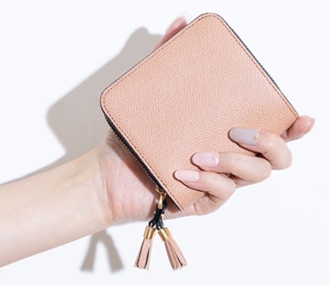エポイ ピンク色 二つ折り財布を持つ手