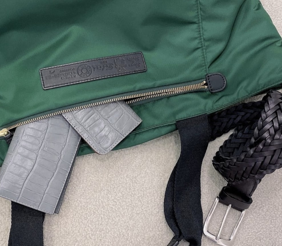 グリーンの鞄から出ているグレーの財布