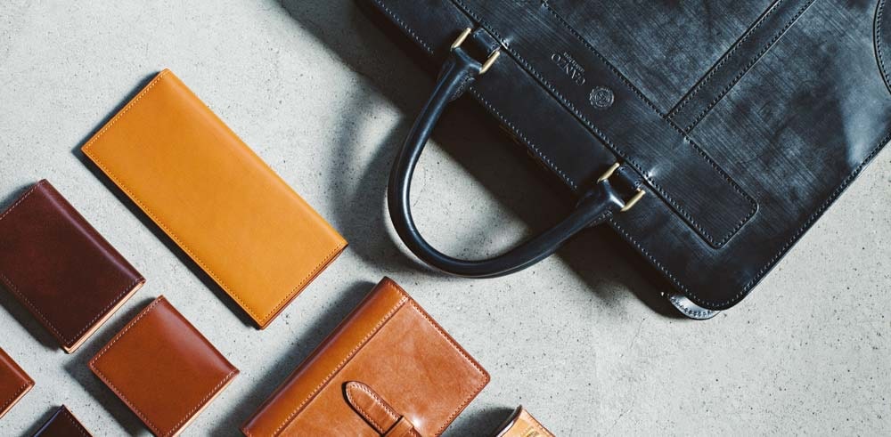 並べられたガンゾのバッグ、財布、iPhoneケース