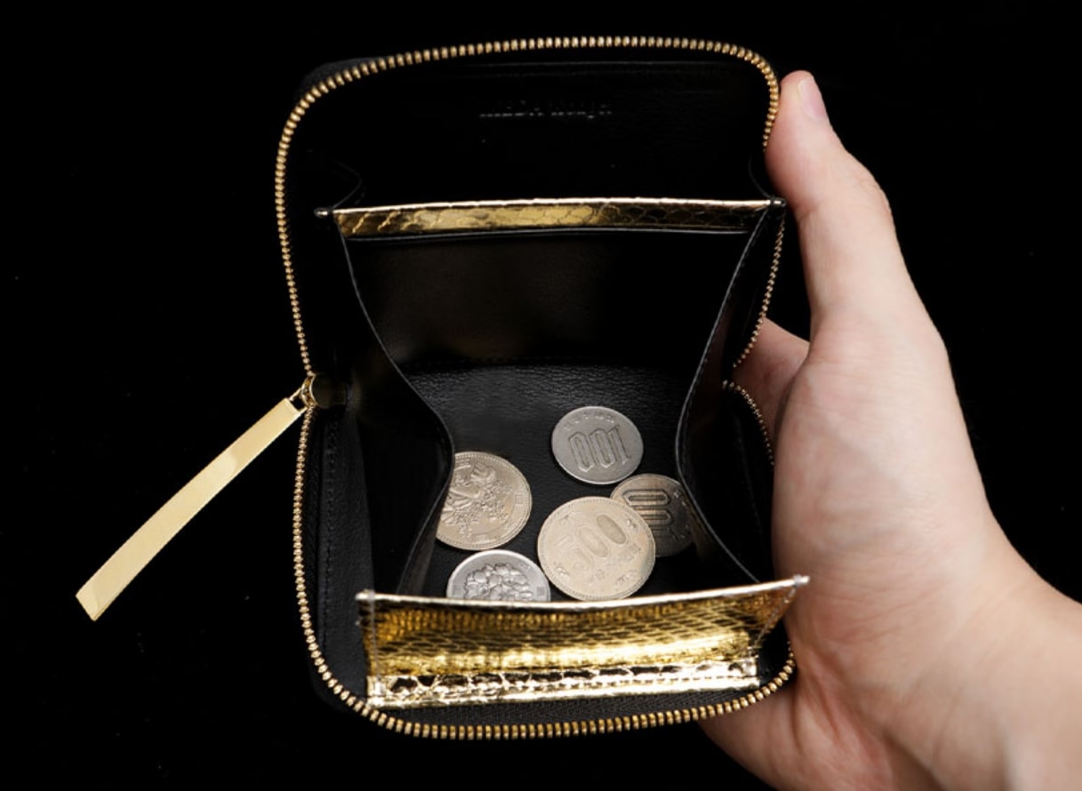 池田工芸のクロコダイル・ゴールドパイソンミニ財布に小銭を入れた姿