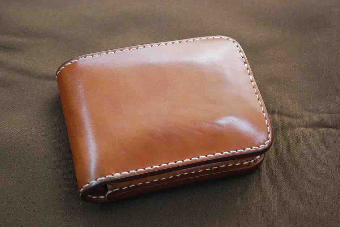 経年変化してツヤと濃い色味が増したカヤンタの二つ折り財布（ナチュラル）