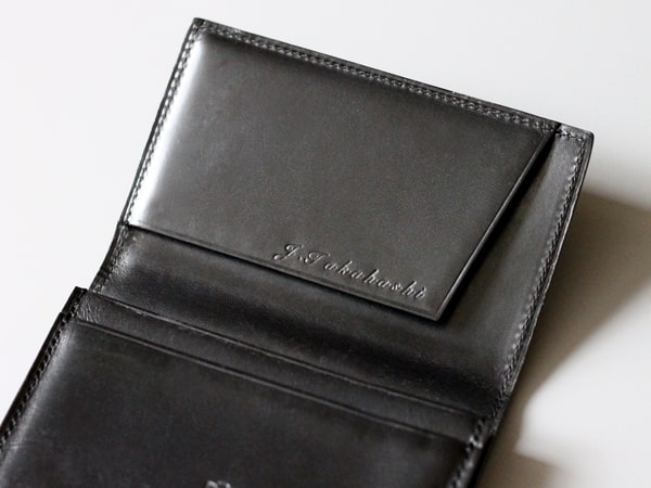 名入れ刻印されたブラックの皮財布