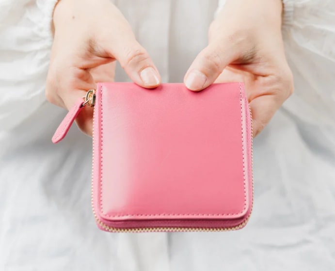 女性の両手に持たれたピンクのMURA（ムラ）のスクエア二つ折り財布