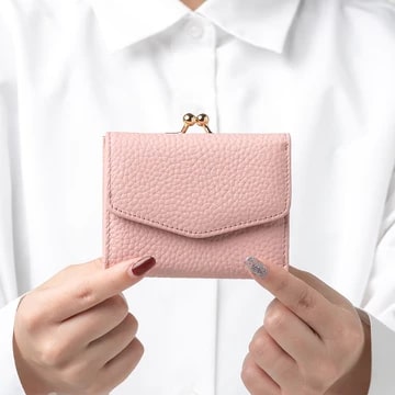 ムラのシュリンクイタリアンレザーがま口ボックス型コイン収納三つ折りミニ財布（ピンク）を持つ女性