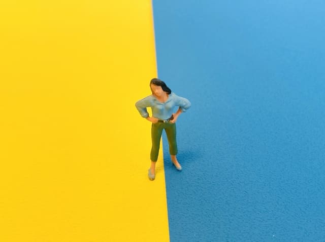 黄色とブルーの境界に立つ人形