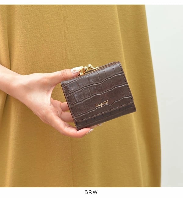 アングリッドのクロコ型押し三つ折り財布がま口を持つ女性